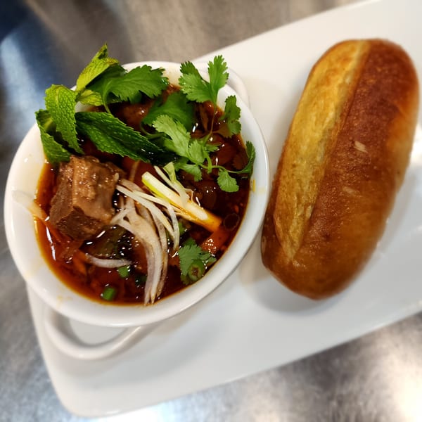 Pho Akaushi's Vietnamese beef stew with herbs and a side of crusty bread.
